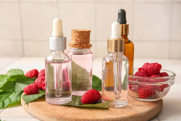 Wooden Board Bottles Cosmetic Raspberry Oil White Tile Background — Stock Photo, Image