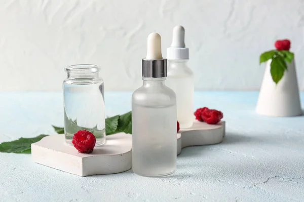Decorative Podium Bottles Cosmetic Raspberry Oil Blue Table — Stock Photo, Image