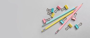 Gri arkaplan üzerinde renkli cilt klipleri ve kalemler metin için boşluk