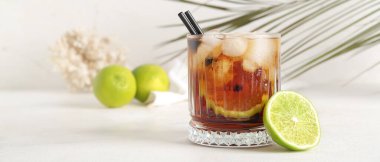 Işık masasında bir bardak soğuk Küba Libre kokteyli  