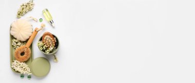 Masaj fırçalı bir şişe serum, açık arkaplan üzerinde perçin ve leylak çiçekleri metin için boşluk