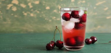 Yeşil zemin üzerinde lezzetli vişneli limonata ve metin için yer var.