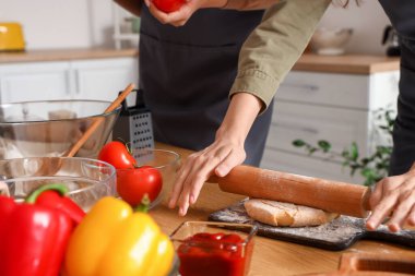 Mutfaktaki yemek kursunda İtalyan pizzası için para dağıtan genç bir kadın.