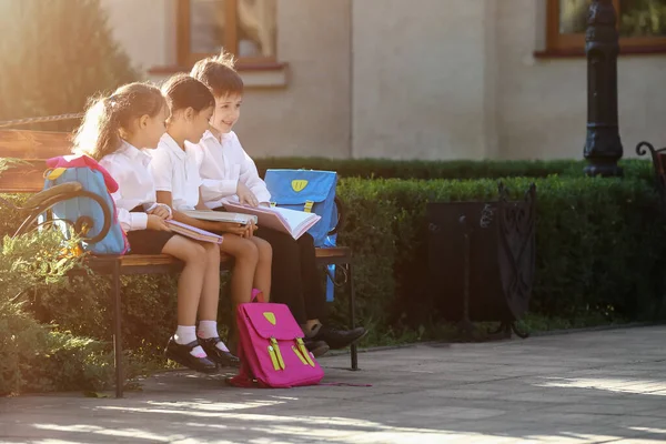 Mali Studenci Książkami Siedzącymi Ławce Świeżym Powietrzu — Zdjęcie stockowe