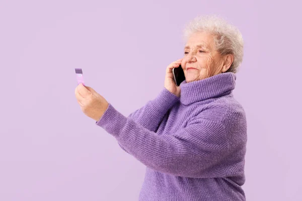 Старшая Женщина Кредитной Картой Разговаривает Мобильному Телефону Фоне Сирени — стоковое фото