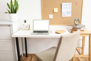 Ofisinde boş ekranı olan modern bir laptop.