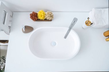 Banyodaki beyaz lavabo, banyo süngeri ve hafif banyoda sabun.