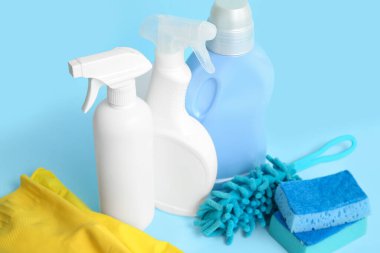 Mavi arka planda farklı temizlik malzemeleri, yakın plan.