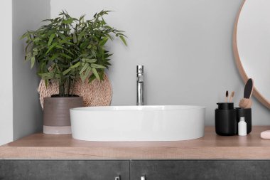 Lavabo ve banyo aksesuarları banyodaki ahşap tezgahın üzerinde.