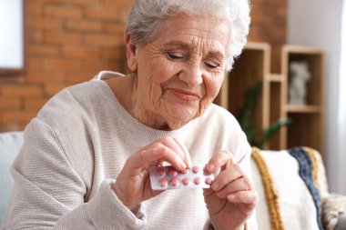 Evde haplı yaşlı bir kadın var, yakın plan.