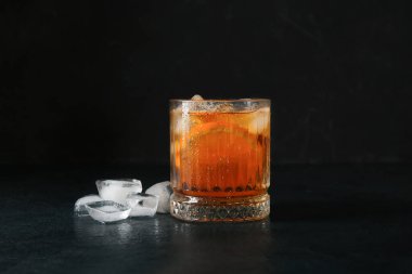 Bir bardak buzlu çay. Siyah arka planda turuncu.