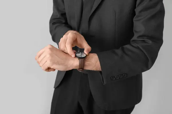 Ung Affärsman Kostym Tittar Armbandsur Ljus Bakgrund Närbild — Stockfoto