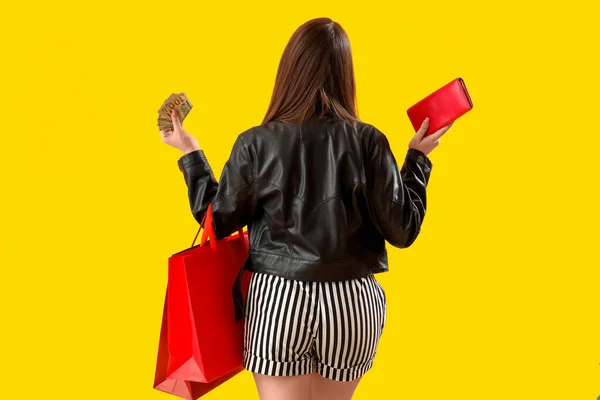 Jonge Vrouw Met Boodschappentassen Geld Portemonnee Gele Achtergrond Achteraanzicht — Stockfoto