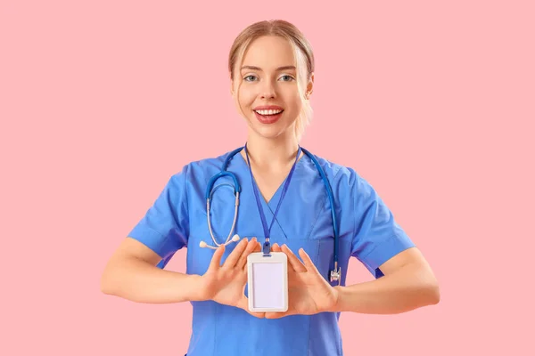 女性医療インターンとともにバッジオンピンクの背景 — ストック写真
