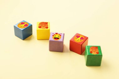 Açık arkaplanda gülümseyen yüzler çizilmiş renkli küpler