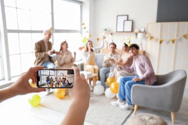 Arkadaşlarının fotoğrafını çeken genç bir kadın doğum gününü evde kutluyor.