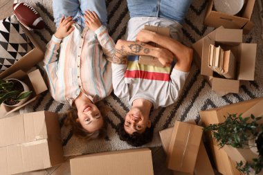 Halı üzerinde taşınan kutuları olan genç bir çift.