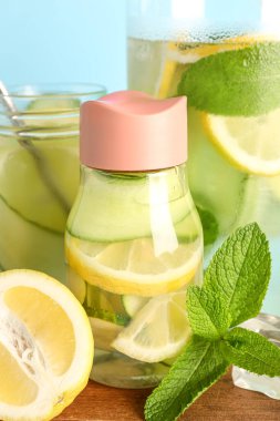 Spor şişesi ve mavi arka planda salatalıklı limonata.