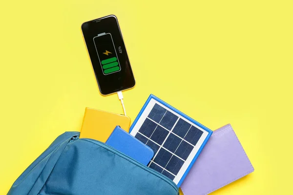Tas Met Notebooks Draagbaar Zonnepaneel Opladen Mobiele Telefoon Gele Achtergrond — Stockfoto