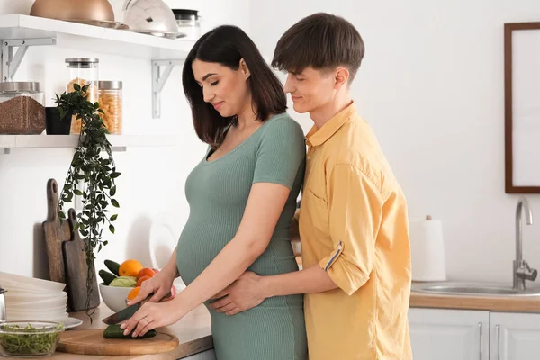 Mladá Těhotná Žena Manželem Krájení Okurka Kuchyni — Stock fotografie