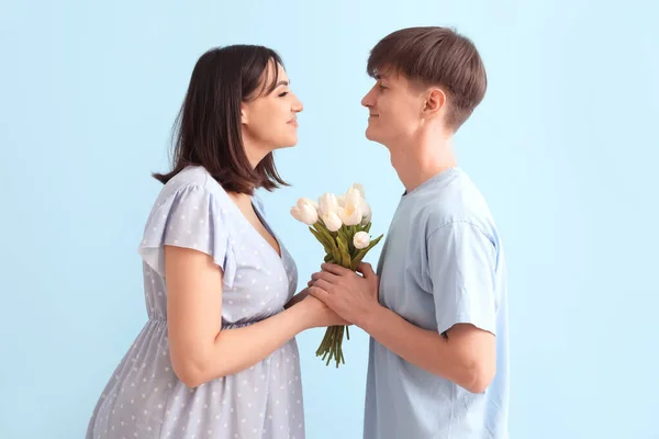 Молодая Беременная Пара Тюльпанами Синем Фоне — стоковое фото