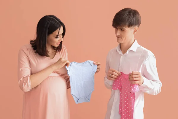 Mladý Těhotný Pár Baby Bodysuits Růžovém Pozadí — Stock fotografie