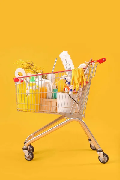 Sarı Arka Planda Çiçekli Temizlik Malzemeleriyle Dolu Bir Alışveriş Arabası — Stok fotoğraf