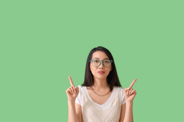 Mooie Aziatische Vrouw Stijlvolle Bril Wijzend Iets Groene Achtergrond — Stockfoto