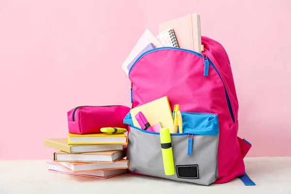 粉红学校背包 白色桌子上靠近彩墙的书 铅笔盒和记号 — 图库照片
