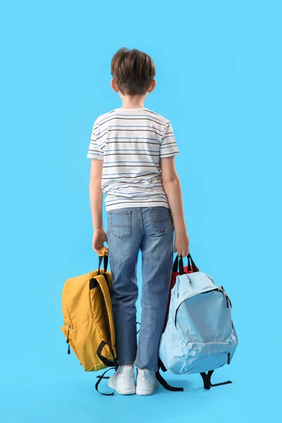 Mavi Arka Planda Sırt Çantaları Olan Küçük Okul Çocuğu — Stok fotoğraf