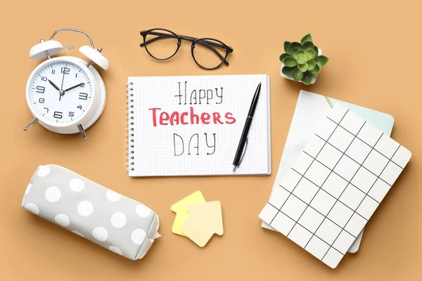 Notebooks with text HAPPY TEACHERS DAY, alarm clock and eyeglasses on orange background