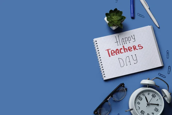Notebook with text HAPPY TEACHERS DAY, eyeglasses and alarm clock on dark blue background