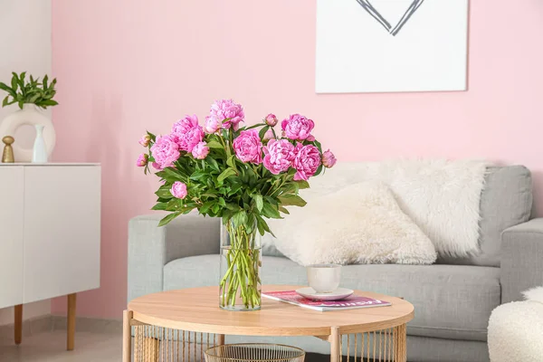 リビングルームでソファとコーヒーテーブルの上のピンクの牡丹の花瓶 — ストック写真