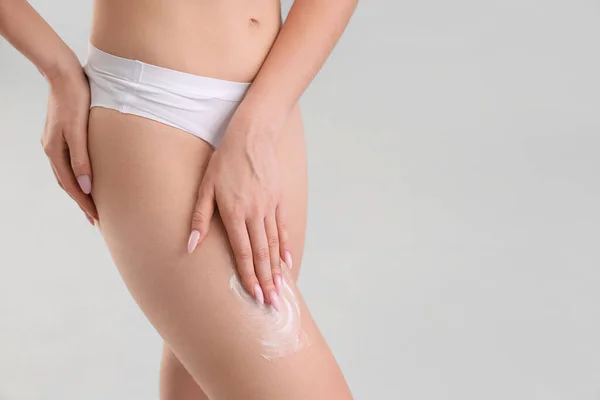 Young Woman Applying Cellulite Cream Her Leg Light Background Closeup — Stock Photo, Image