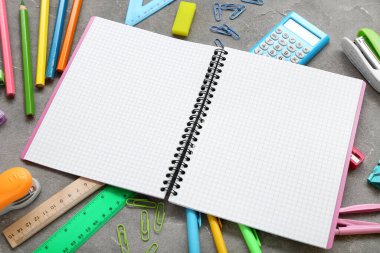 Grunge gri arkaplanda kırtasiye malzemesi olan boş bir defter