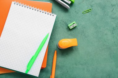 Boş defter ve grunge yeşil arkaplan üzerindeki farklı kırtasiye