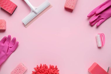 Pembe arka planda farklı temizlik malzemelerinden yapılmış çerçeve