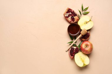 Rosh Hashanah kutlaması için bir kase bal, nar ve elma (Yahudi Yeni Yılı) pembe arka planda