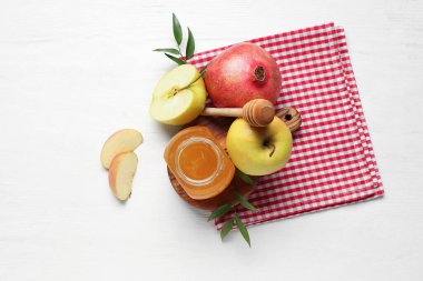 Beyaz ahşap arka planda Rosh Hashanah kutlaması (Yahudi Yeni Yılı) için bal, nar ve elma dolu tahta pano