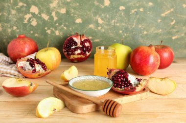 Tahta masada, Rosh Hashanah kutlaması (Yahudi Yeni Yılı) için bir kase bal, nar ve elmayla birlikte.