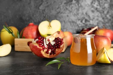 Rosh Hashanah kutlaması için kavanoz bal, nar ve elma (Yahudi Yeni Yılı) siyah masada