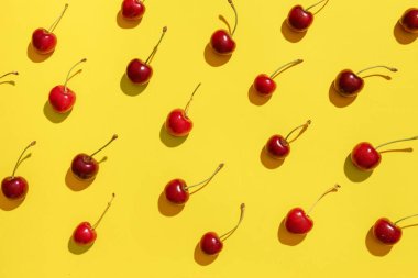 Sarı arka planda bir sürü tatlı kiraz