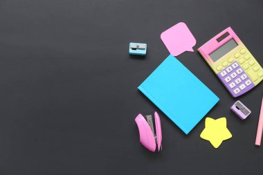 Siyah karatahtanın üzerinde farklı kırtasiye malzemesi olan hesap makinesi