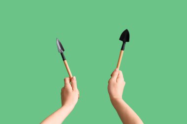 Bahçıvan yeşil arka planda tırmık ve kürekle