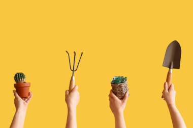 Sarı arka planda kürek, tırmık ve sulu şeyler olan insanlar.