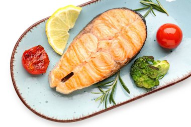 Beyaz arka planda lezzetli ızgara somon bifteği tabağı.