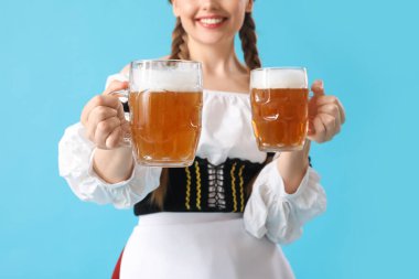 Mavi arka planda birası olan güzel Ekim Festivali garsonu, yakın plan.