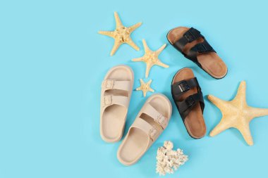 Mavi arka planda parmak arası terlikler ve deniz yıldızları, üst görünüm