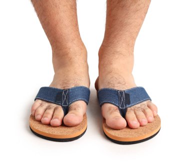 Beyaz arka planda parmak arası terlik giymiş erkek bacakları