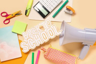 Kağıt metin ile kırtasiye ve megafon açık sarı arka planda okula geri dönsün